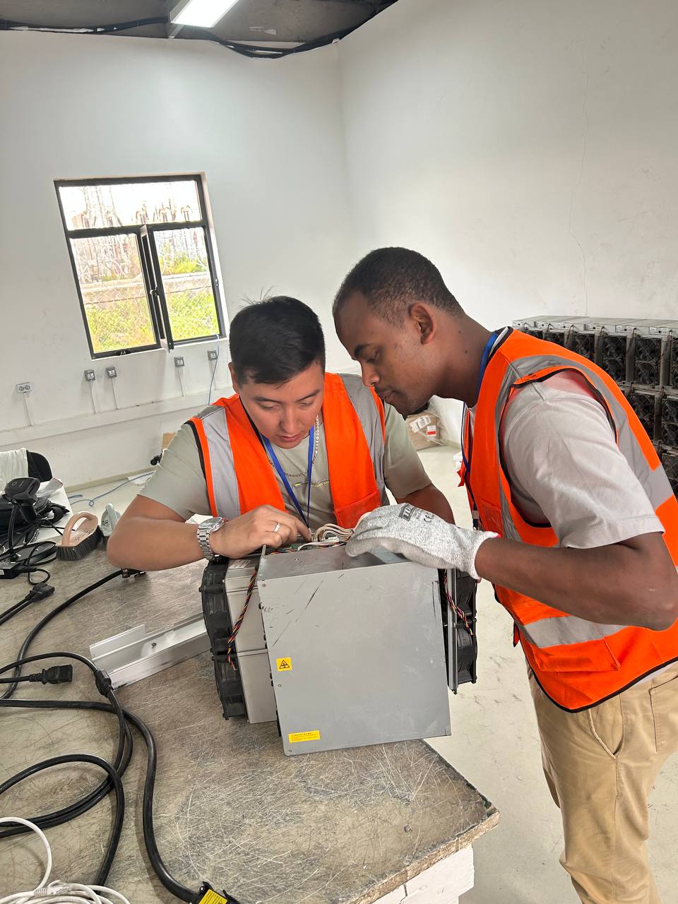 Technicians repairing an ASIC miner